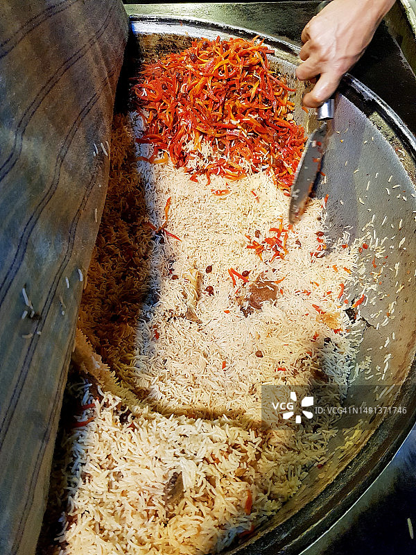 大锅里盛放的大量阿富汗抓饭，配有胡萝卜碎图片素材