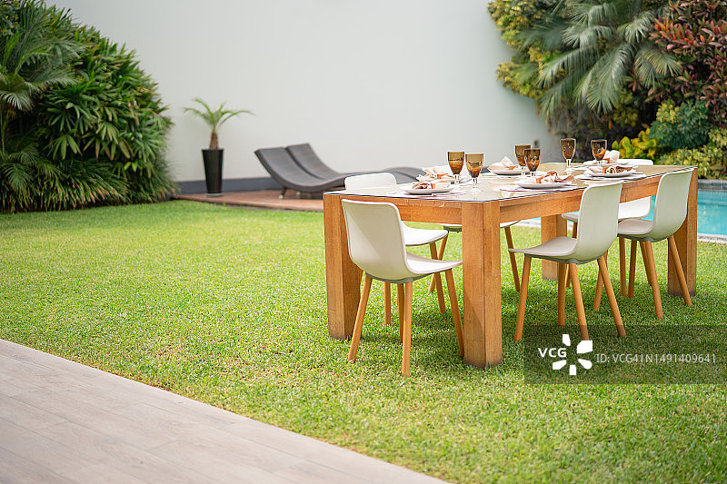 花园里摆放着盘子和酒杯的桌子图片素材