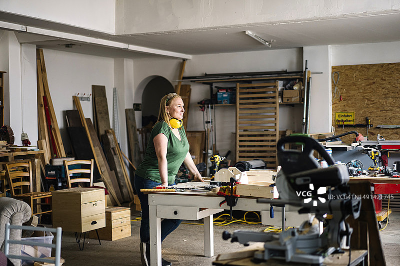 金发女人站在木工车间里图片素材