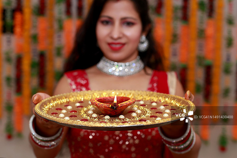 在排灯节上，手持装饰盘的印度年轻女性图片素材