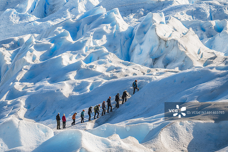 人们在阿根廷莫雷诺冰川上徒步旅行图片素材