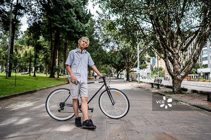 在公园扶着自行车的青少年男孩肖像图片素材