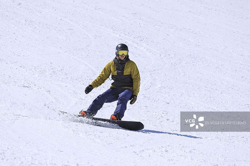 滑雪：年轻男子在山坡上滑雪图片素材