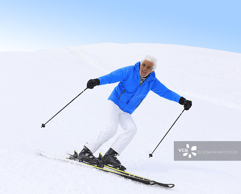 充满活力的灰发老人享受滑雪乐趣图片素材