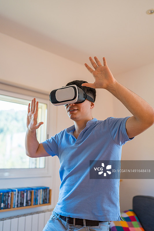男人在家戴VR头显玩电子游戏图片素材