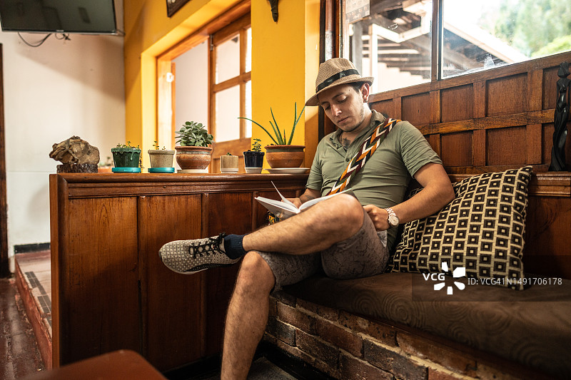年轻旅行者在旅馆看书图片素材