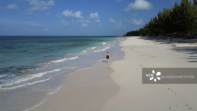探索偏远海滩的女子航拍图片素材