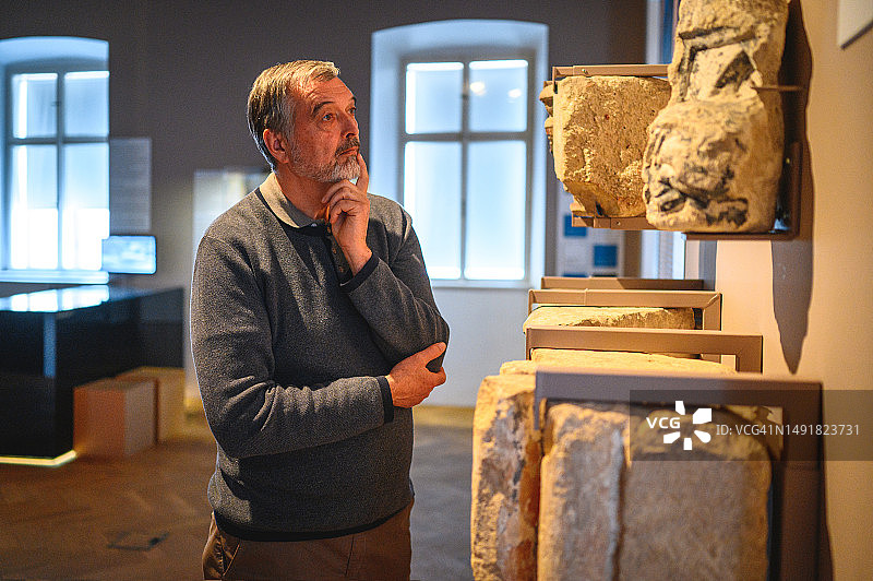 年长的白人男子欣赏古墓碑图片素材