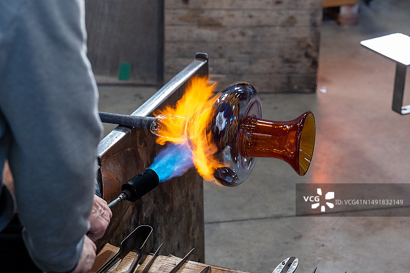 意大利威尼斯穆拉诺传统玻璃吹制工人塑造液态玻璃图片素材