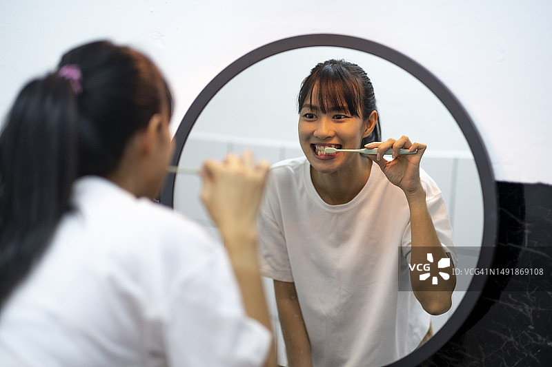 亚洲女性照镜子刷牙图片素材