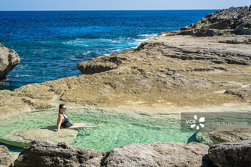 在海边享受潮汐池的女人鸟瞰图图片素材