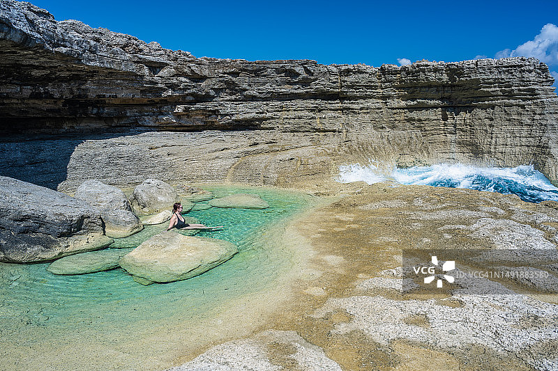在海边享受潮汐池的女人鸟瞰图图片素材