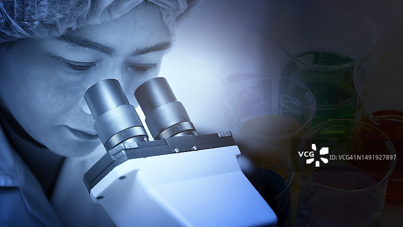 微生物学家在实验室使用显微镜特写图片素材
