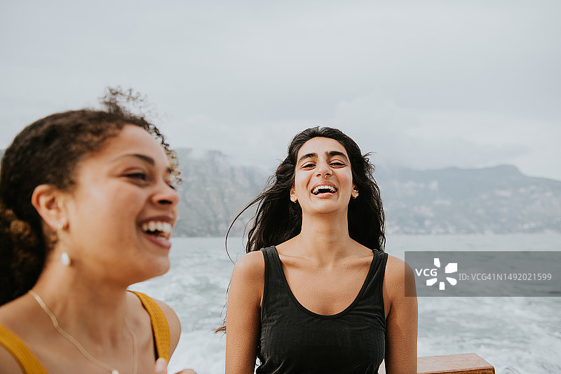 两位美丽的年轻女性在海边欢笑图片素材