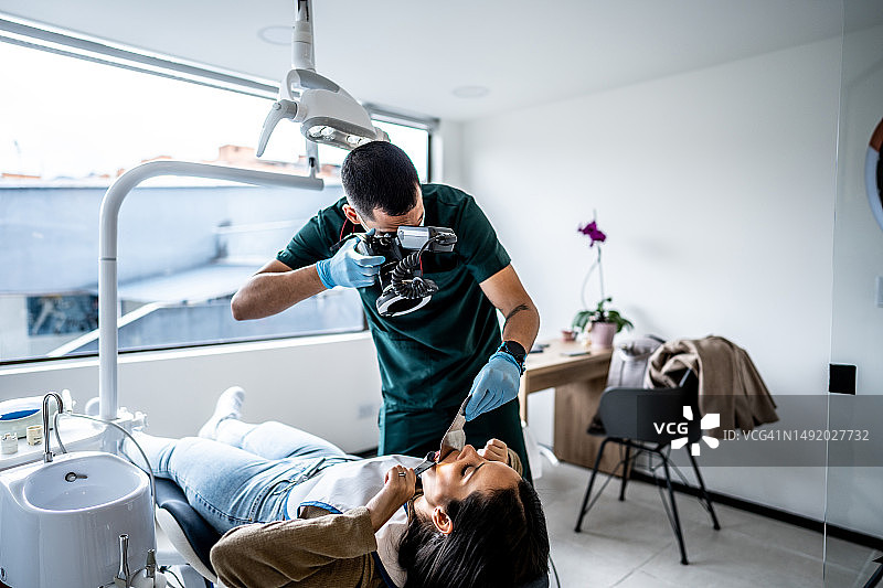 牙科诊所正畸医生为患者牙齿拍照图片素材