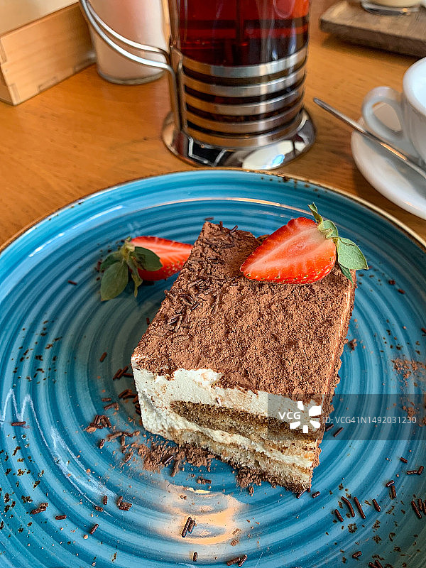 咖啡馆里蓝盘草莓提拉米苏图片素材