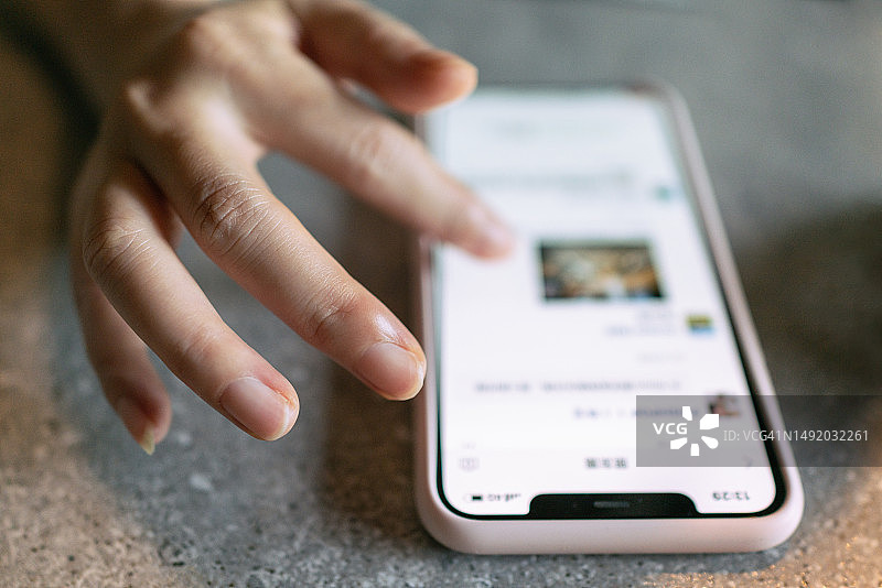 在桌面上操作智能手机的女人图片素材