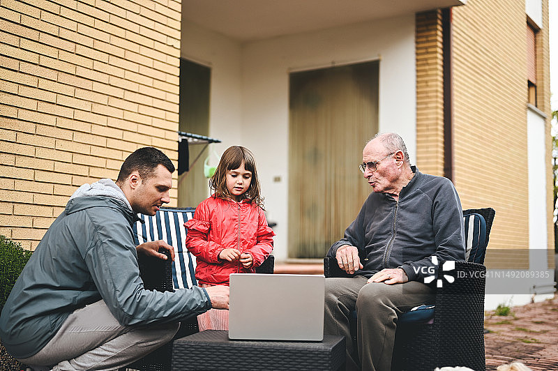 一家人在露台上一起使用电脑图片素材