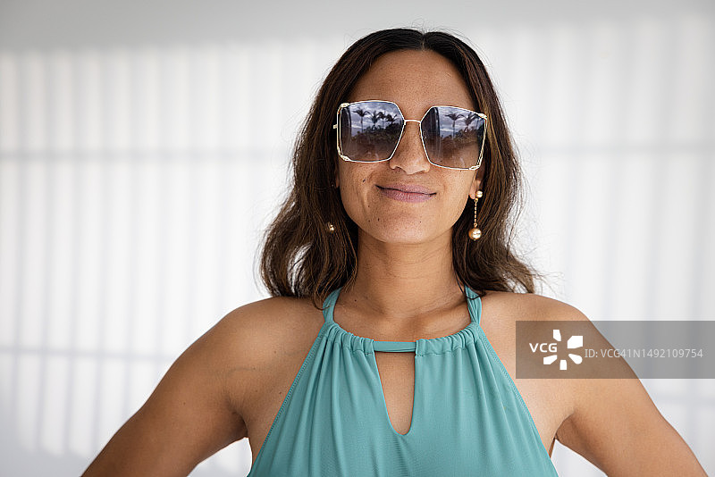 戴着黑色太阳镜的微笑长发女人图片素材