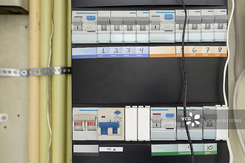房屋内的电气控制面板，上面并排排列着几个开关，正面视图图片素材