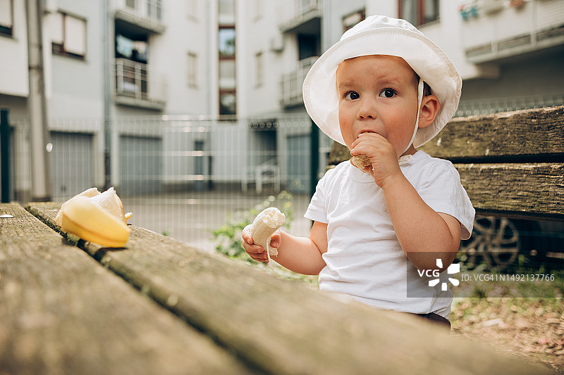 儿童在长凳上吃香蕉图片素材