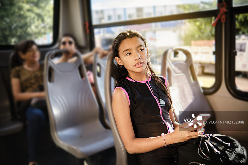 坐在公交车上手拿手机的女人图片素材