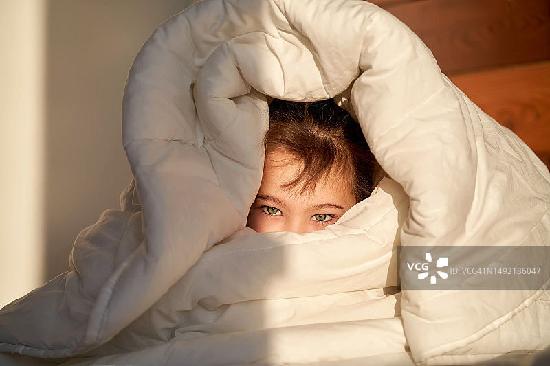 女孩裹着毯子坐着图片素材