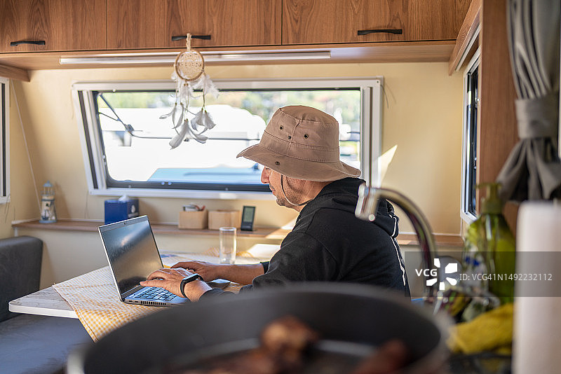 在房车里用笔记本电脑的男人图片素材