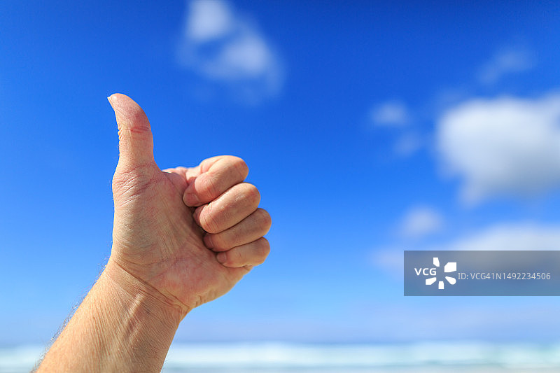 点赞手势，带文案空间的蓝天图片素材