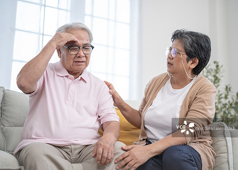 年长的女人帮助和支持头痛的年长男人图片素材