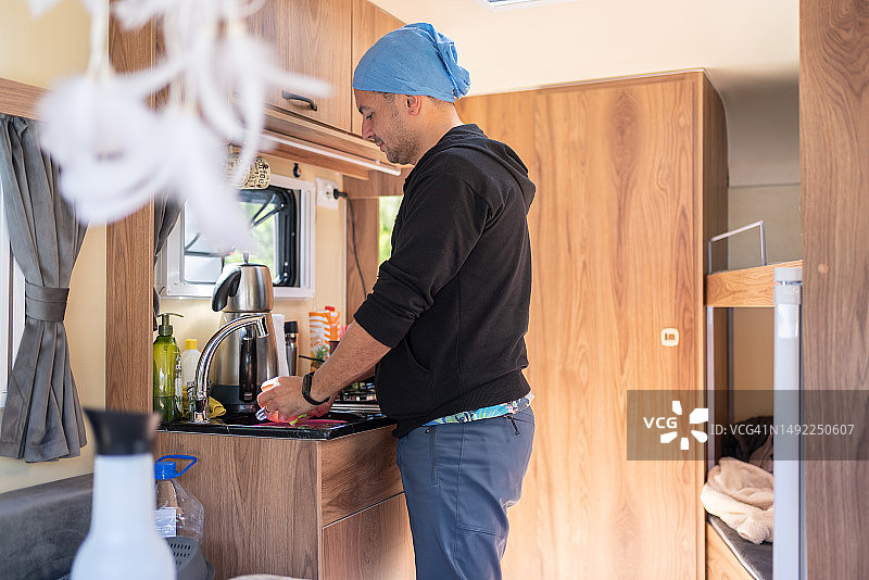 男人在房车厨房洗碗图片素材