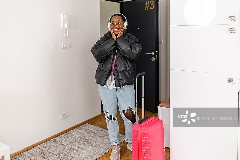 拖着行李箱到达新公寓的年轻非裔美国女子图片素材