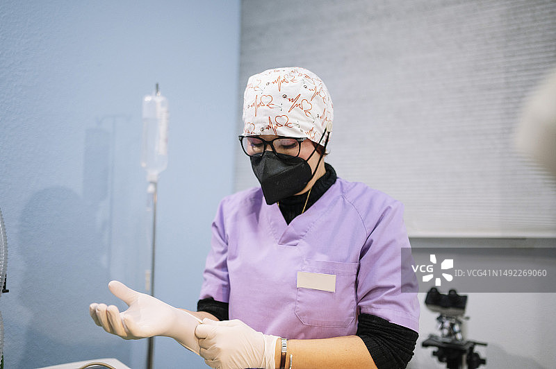 戴着口罩在诊所工作的女兽医图片素材