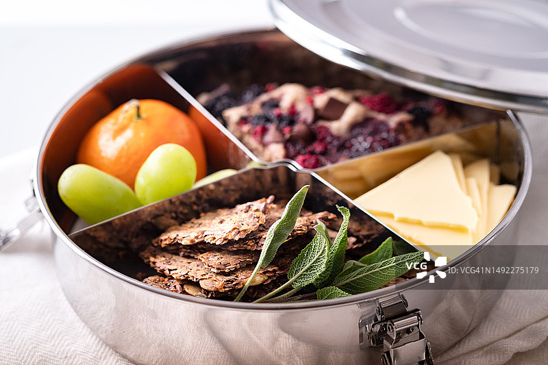 可重复使用容器中的纯素午餐（饼干、奶酪、薄煎饼、水果）图片素材