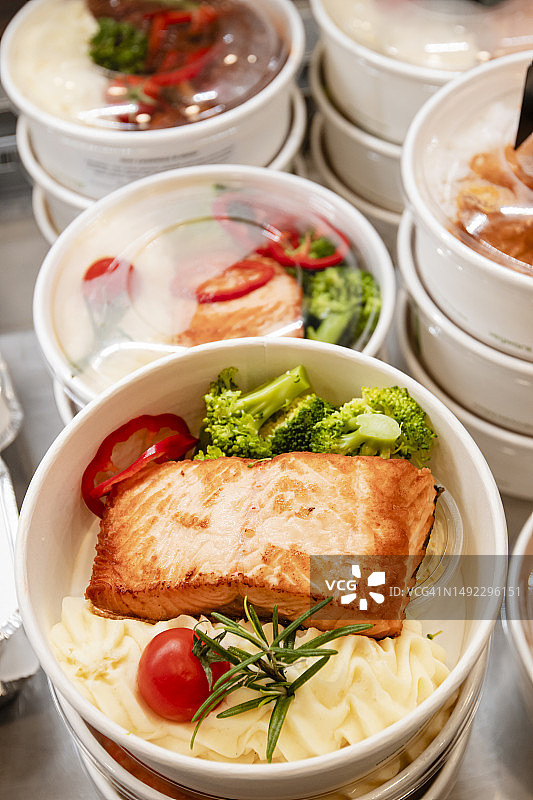 可降解外卖容器中的烤三文鱼晚餐，顶视图，特写图片素材