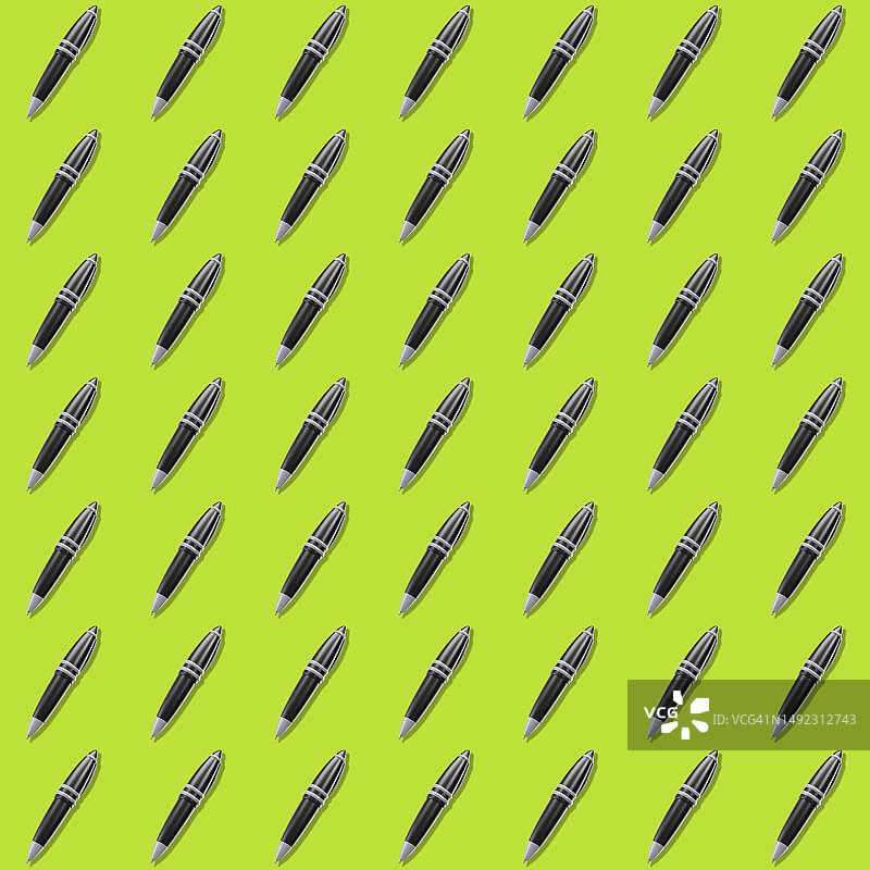 绿色表面图案背景上的黑色圆珠笔图片素材