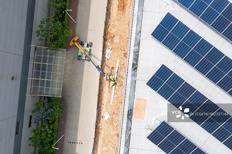 屋顶太阳能电池板和电梯上的建筑工人图片素材