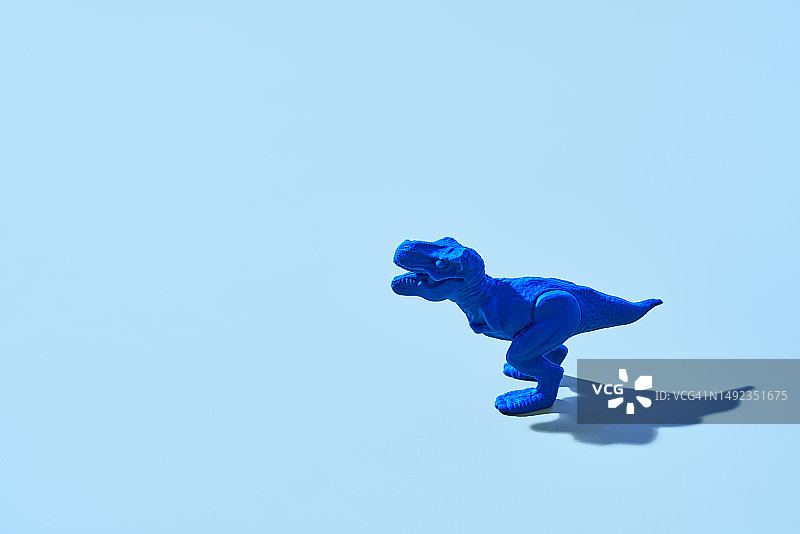 蓝色背景上的蓝色塑料霸王龙图片素材