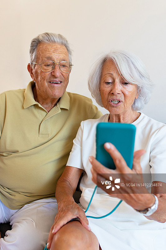 微笑老年夫妇在智能手机上进行视频通话图片素材