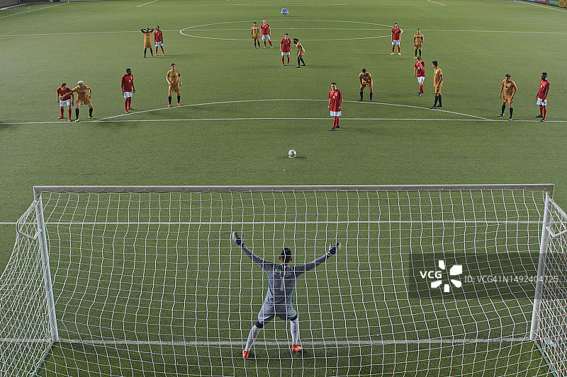 一名足球守门员在罚点球时举起双臂挡住球门图片素材