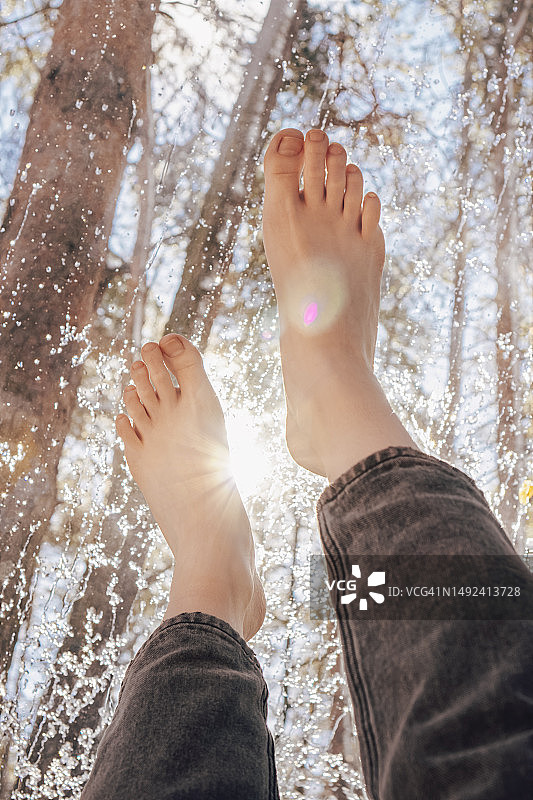 阳光下做足部护理的女人，第一人称视角图片素材