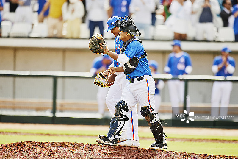 棒球比赛中投手和捕手讨论广角镜头图片素材