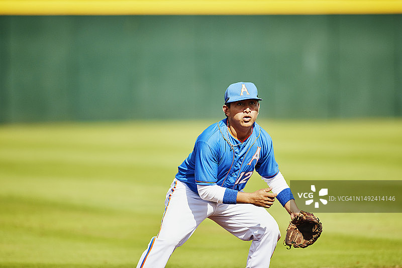 棒球比赛中内场队员移动接球的中景广角镜头图片素材