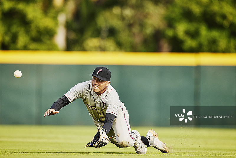 棒球比赛中外野手飞身接球的广角镜头图片素材