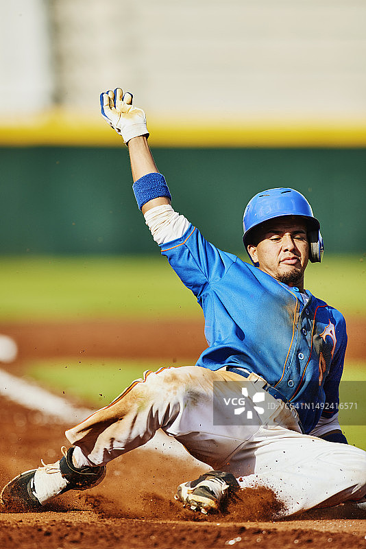 棒球比赛中跑垒员滑入本垒的广阔镜头图片素材