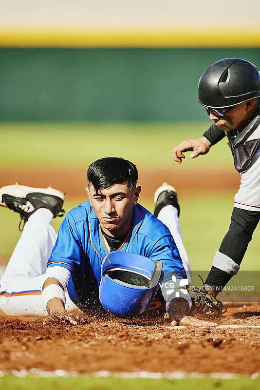 棒球比赛中跑垒员滑入本垒的广阔镜头图片素材