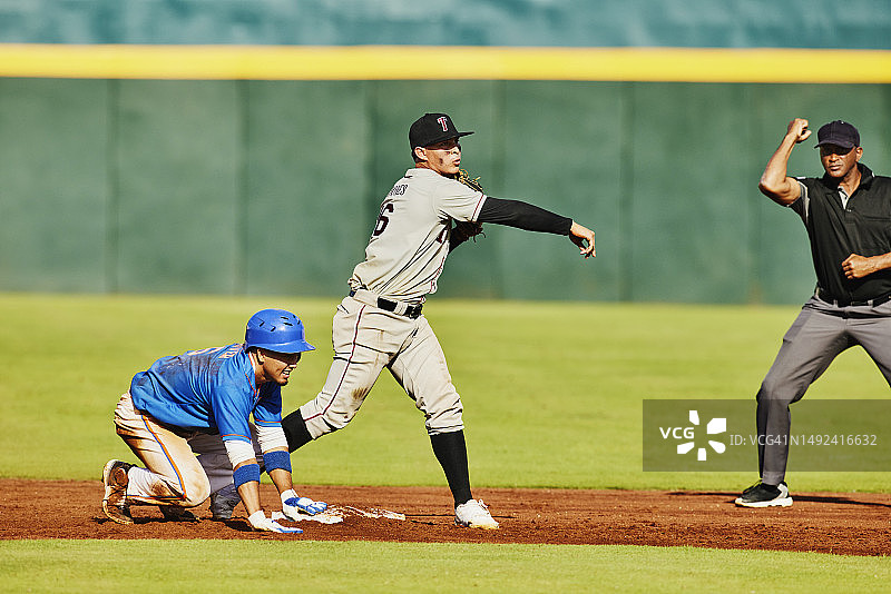 棒球比赛中，二垒手向一垒投球图片素材