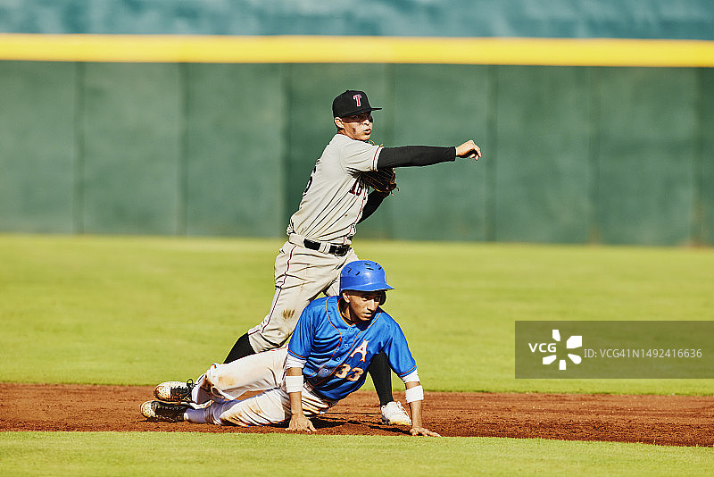 棒球比赛中，二垒手向一垒投球图片素材