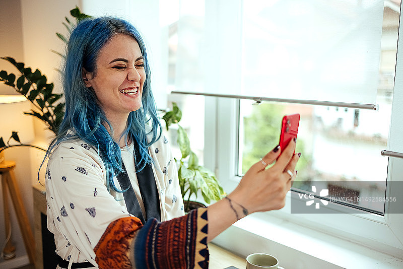 女人在客厅用智能手机进行视频通话图片素材