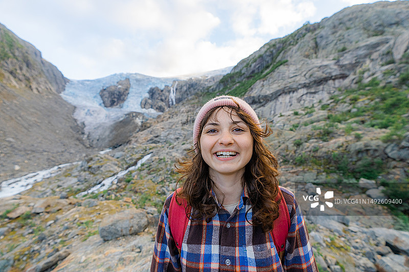 在约斯特达尔冰川背景下的微笑女性图片素材